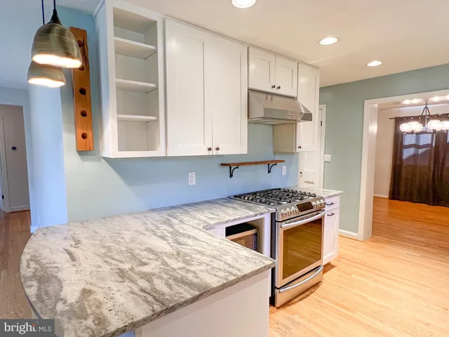 a kitchen with a stove and a wooden floors