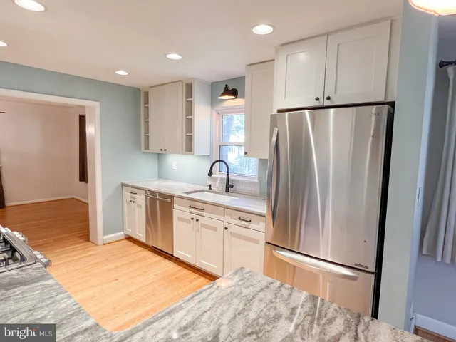 a kitchen with stainless steel appliances granite countertop a refrigerator sink and cabinets