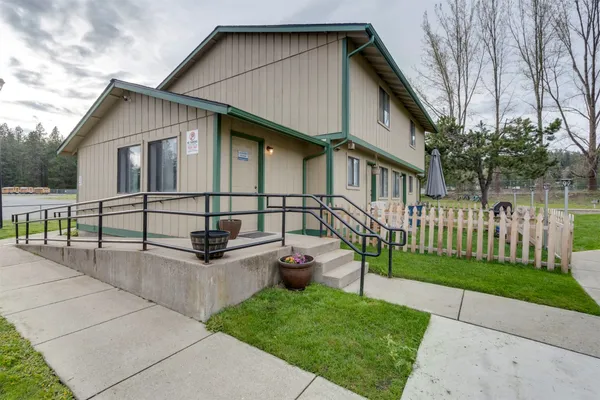 a white house that has tree in front of it