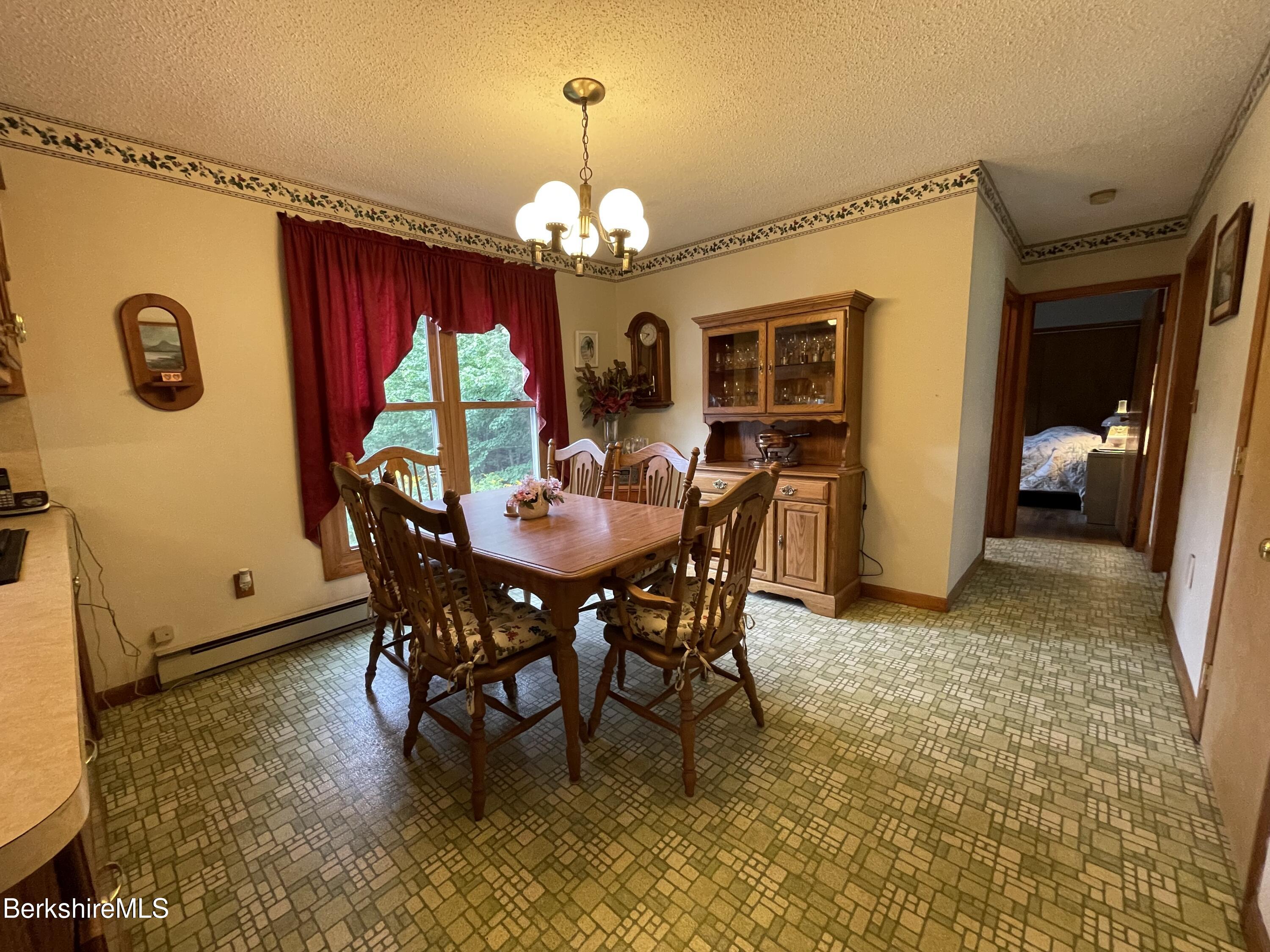 231 Central Shaft Road Florida, MA 01247 - Photo 7 of 21 a view of a dining room with furniture and a chandelier