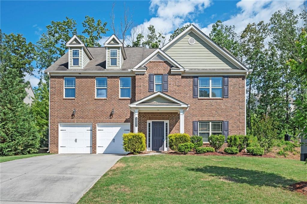 a front view of a house with a yard and trees