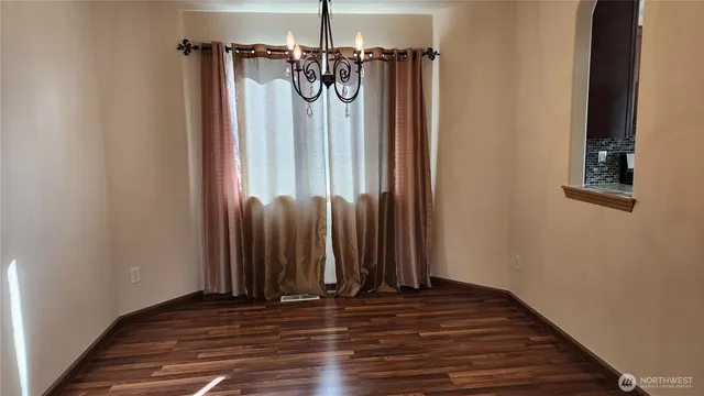 a view of a hallway with wooden floor and dining room