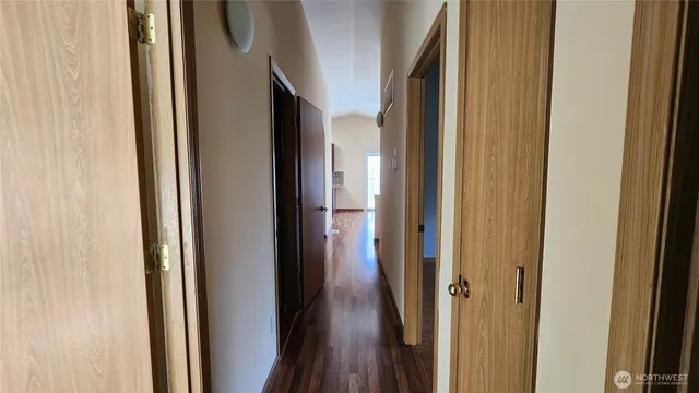 a view of a hallway with wooden floor and staircase