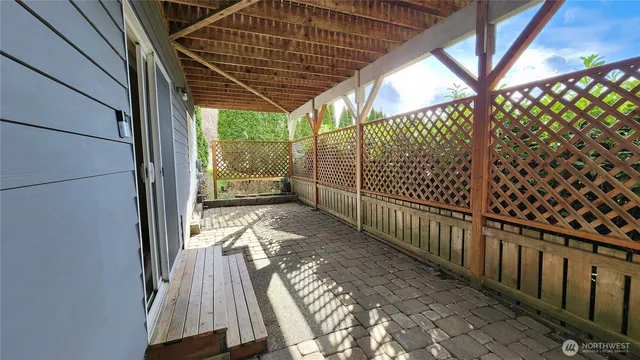 a backyard of a house with plants and large tree