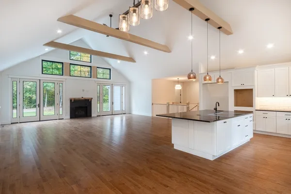 a kitchen with stainless steel appliances granite countertop a sink a stove and a wooden floors