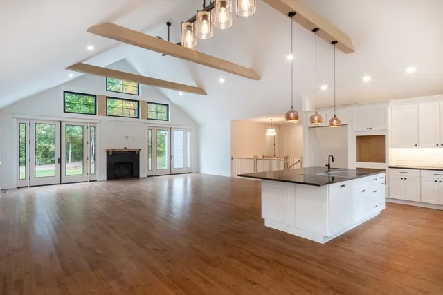 a kitchen with stainless steel appliances granite countertop a sink a stove and a wooden floors