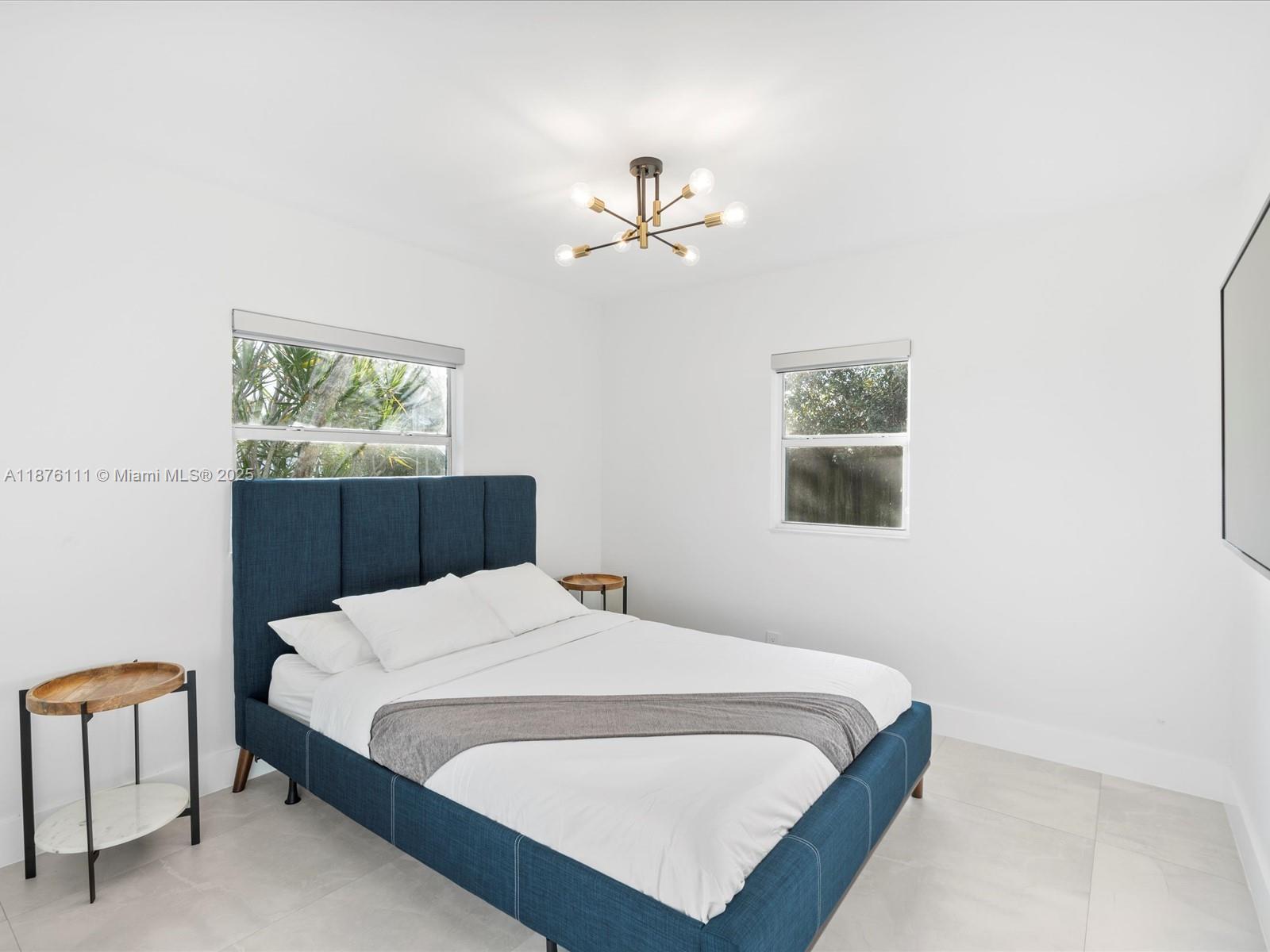 5731 Southwest 54th Terrace Davie, FL 33314 - Photo 18 of 22 a bedroom with a bed a window and painting on the wall