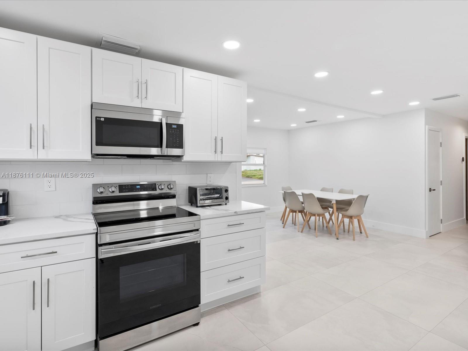 5731 Southwest 54th Terrace Davie, FL 33314 - Photo 7 of 22 a kitchen with granite countertop white cabinets and stainless steel appliances