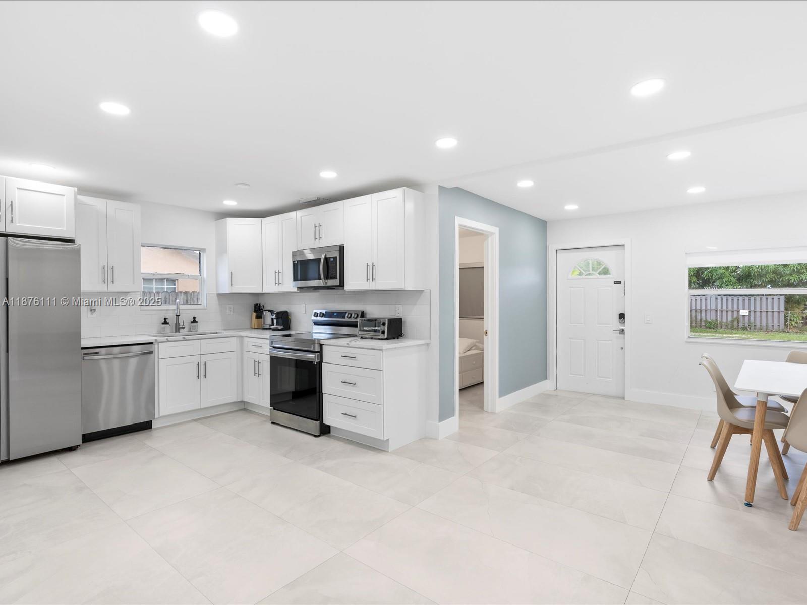5731 Southwest 54th Terrace Davie, FL 33314 - Photo 8 of 22 a kitchen with white cabinets and stainless steel appliances