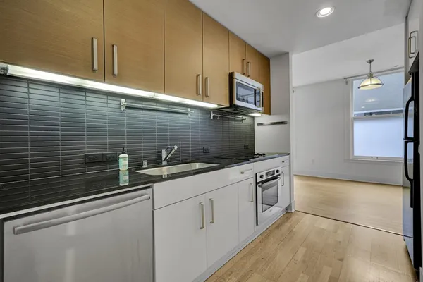 a kitchen with stainless steel appliances kitchen island granite countertop a stove microwave and cabinets