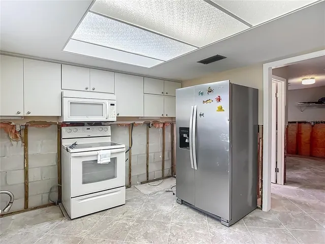 a kitchen with stainless steel appliances a refrigerator sink and cabinets