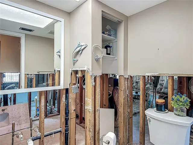 a large bedroom with a large bed a chandelier and closet