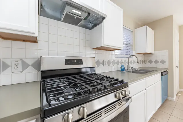 a stove top oven sitting inside of a kitchen