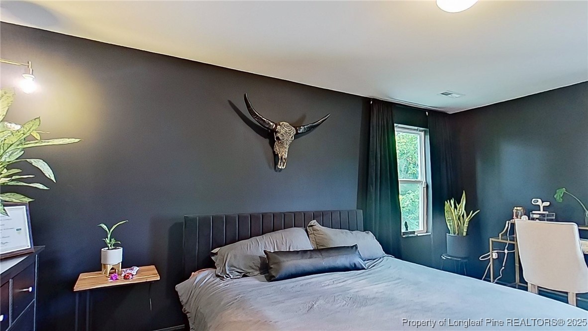 29 York Court Spring Lake, NC 28390 - Photo 14 of 22 a bedroom with a bed and a potted plant