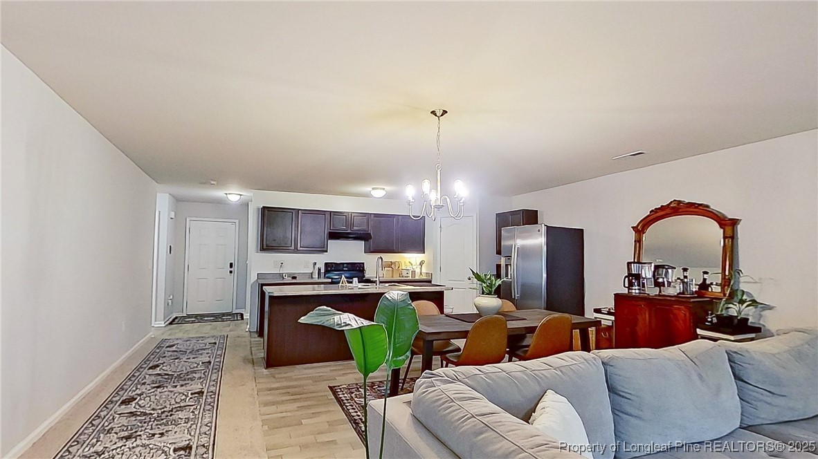 29 York Court Spring Lake, NC 28390 - Photo 9 of 22 a living room with furniture a fireplace and a chandelier