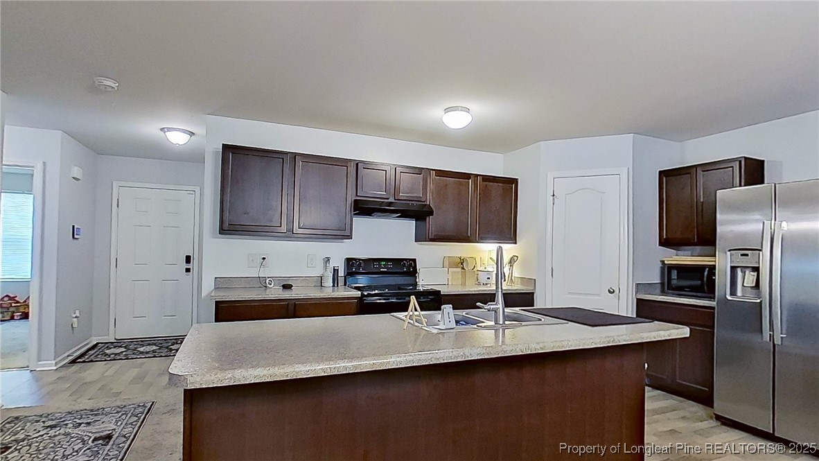29 York Court Spring Lake, NC 28390 - Photo 10 of 22 a kitchen with kitchen island granite countertop a sink refrigerator and cabinets