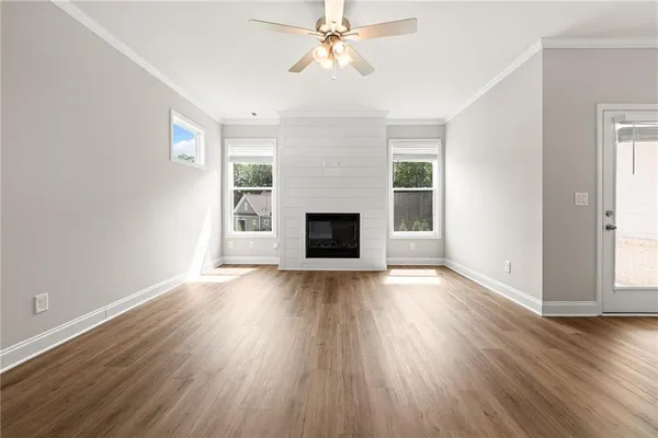 a view of a livingroom with wooden floor and a ceiling fan
