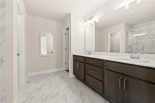 a bathroom with double vanity sinks and a mirror