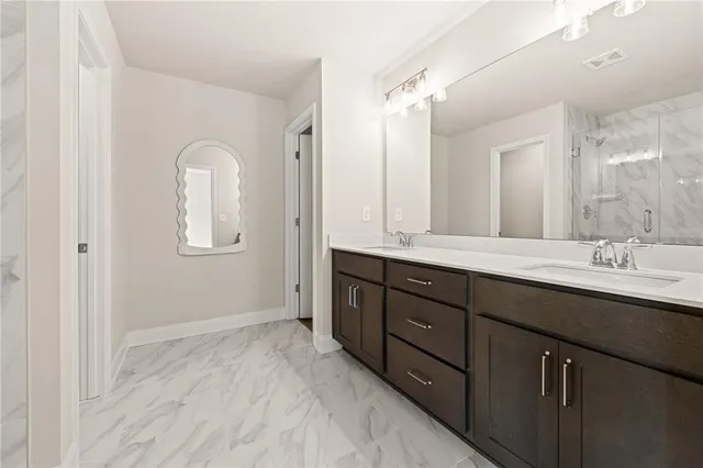 a bathroom with double vanity sinks and a mirror