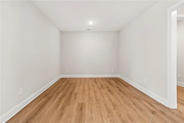 a view of an empty room with wooden floor