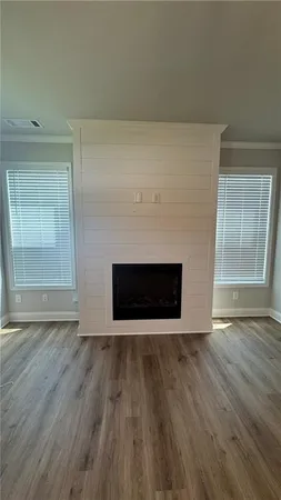 an empty room with wooden floor and fireplace