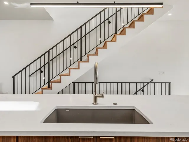a view of staircase with white walls and a bathtub