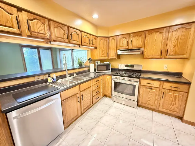 a kitchen with stainless steel appliances granite countertop a stove sink and cabinets