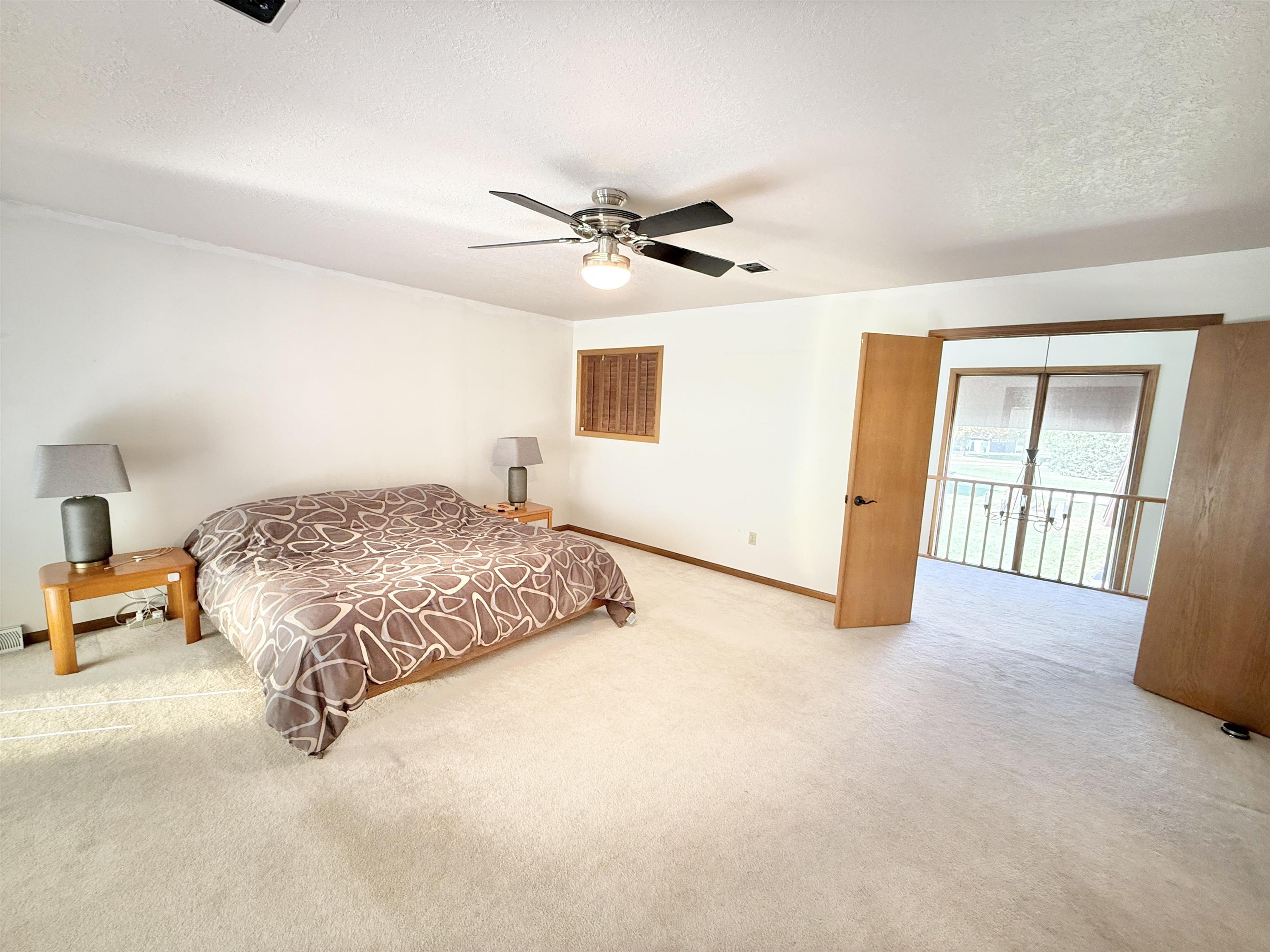 5449 South Branch Court Rochelle, IL 61068 - Photo 22 of 45 a large bedroom with a bed and wooden floor