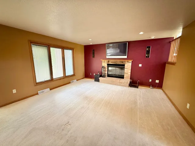 a view of an empty room with a fireplace and a window