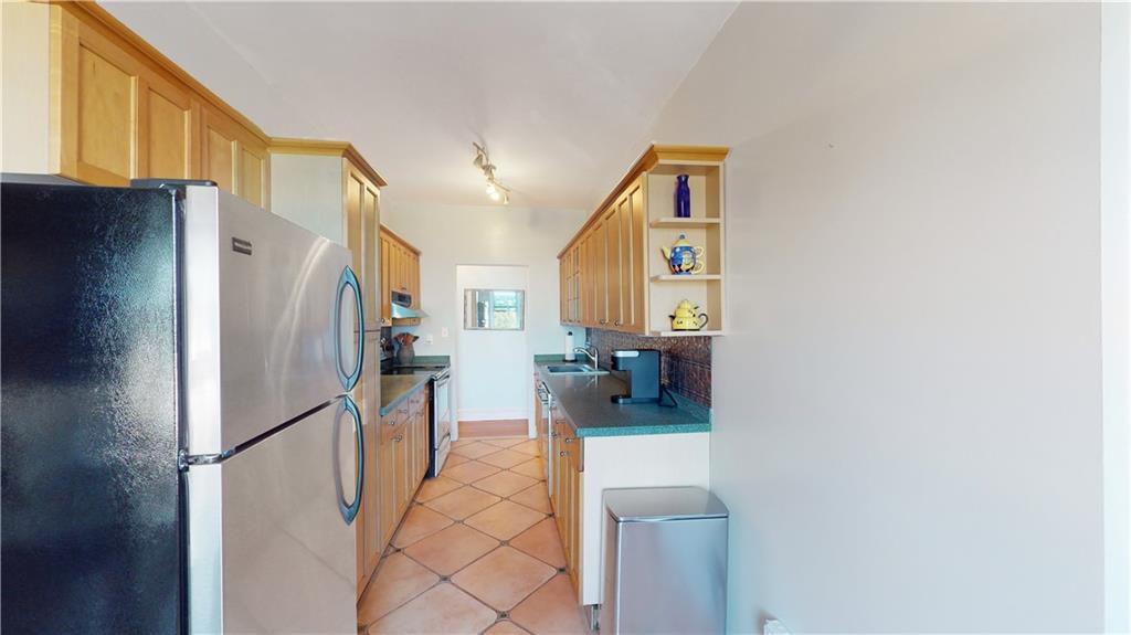 9701 Shore Road, Unit 1N Brooklyn, NY 11209 - Photo 5 of 18 a kitchen with stainless steel appliances a refrigerator and a cabinets