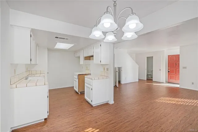 a view of a kitchen with a sink dishwasher and wooden floor