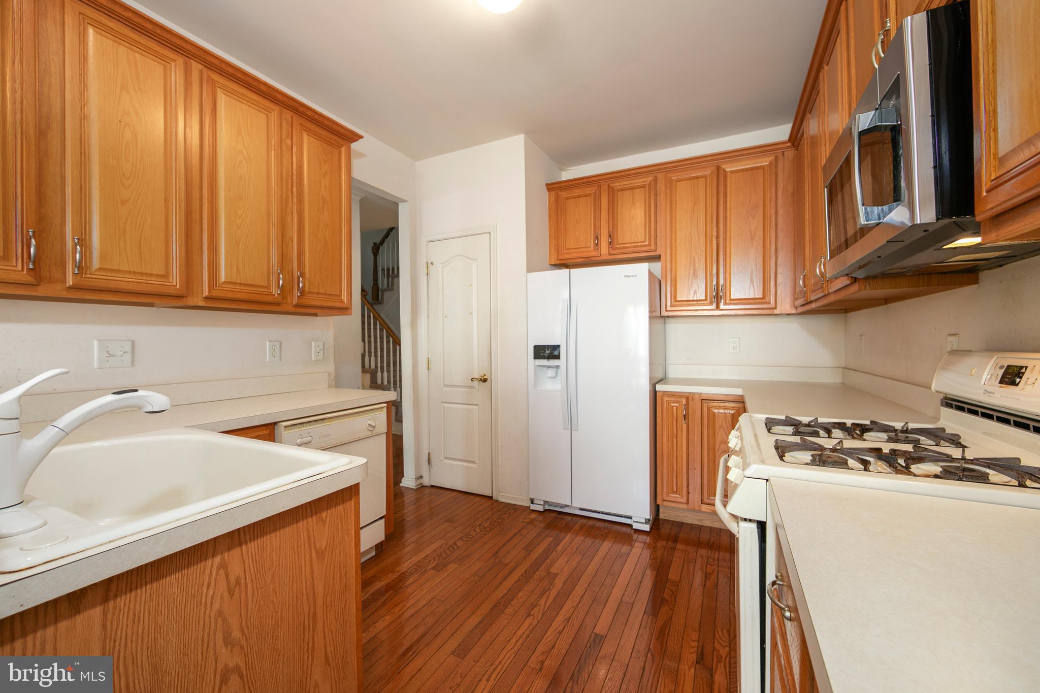 342 Huntington Drive Delran, NJ 08075 - Photo 13 of 45 a kitchen with stainless steel appliances granite countertop a refrigerator a sink dishwasher and wooden cabinets with wooden floor