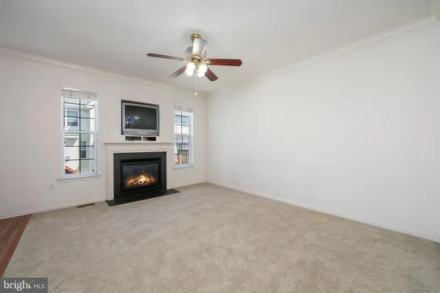 a view of an empty room with a fireplace and a window