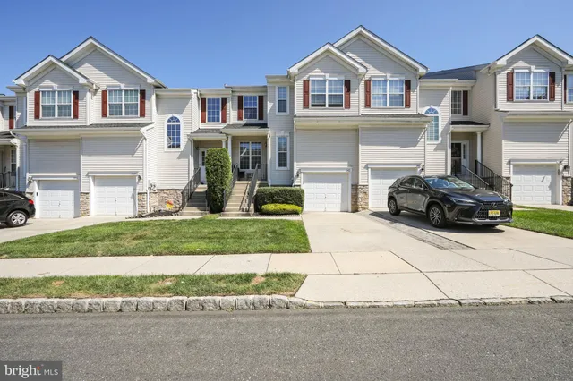 a front view of a house with a yard and a garage