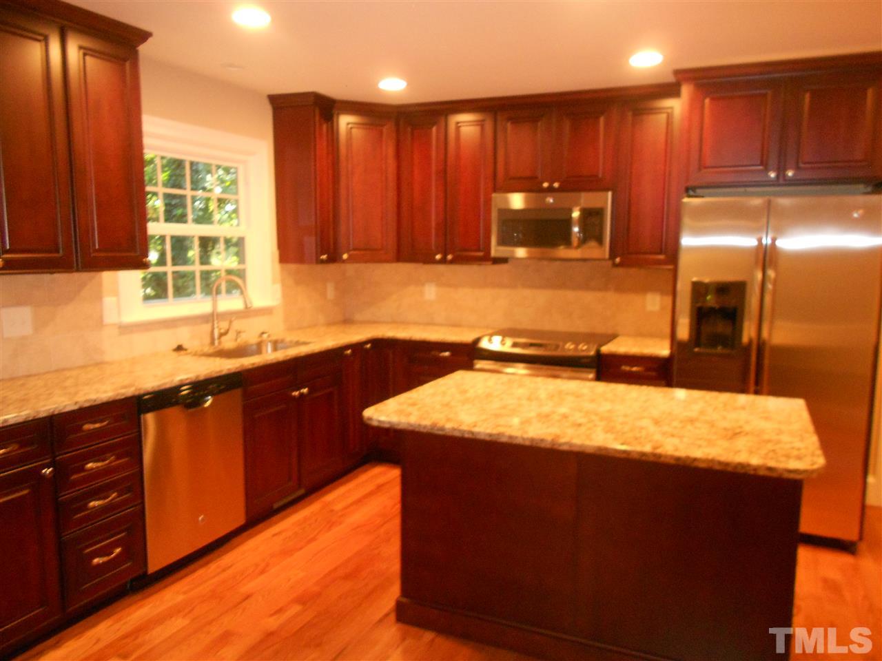 1208 Bancroft Street Raleigh, NC 27612 - Photo 13 of 22 a kitchen with a sink and a wooden cabinets