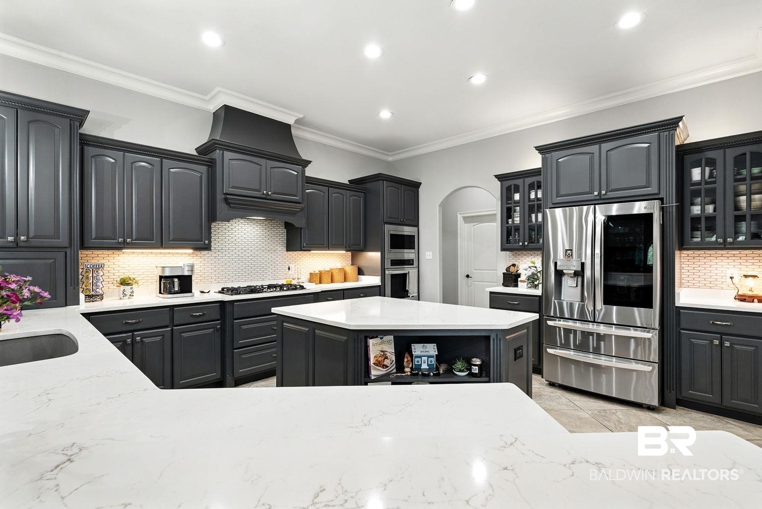 23357 Carnoustie Drive Foley, AL 36535 - Photo 33 of 99 Kitchen with backsplash, appliances with stainless steel finishes, arched walkways, ornamental molding, and glass insert cabinets
