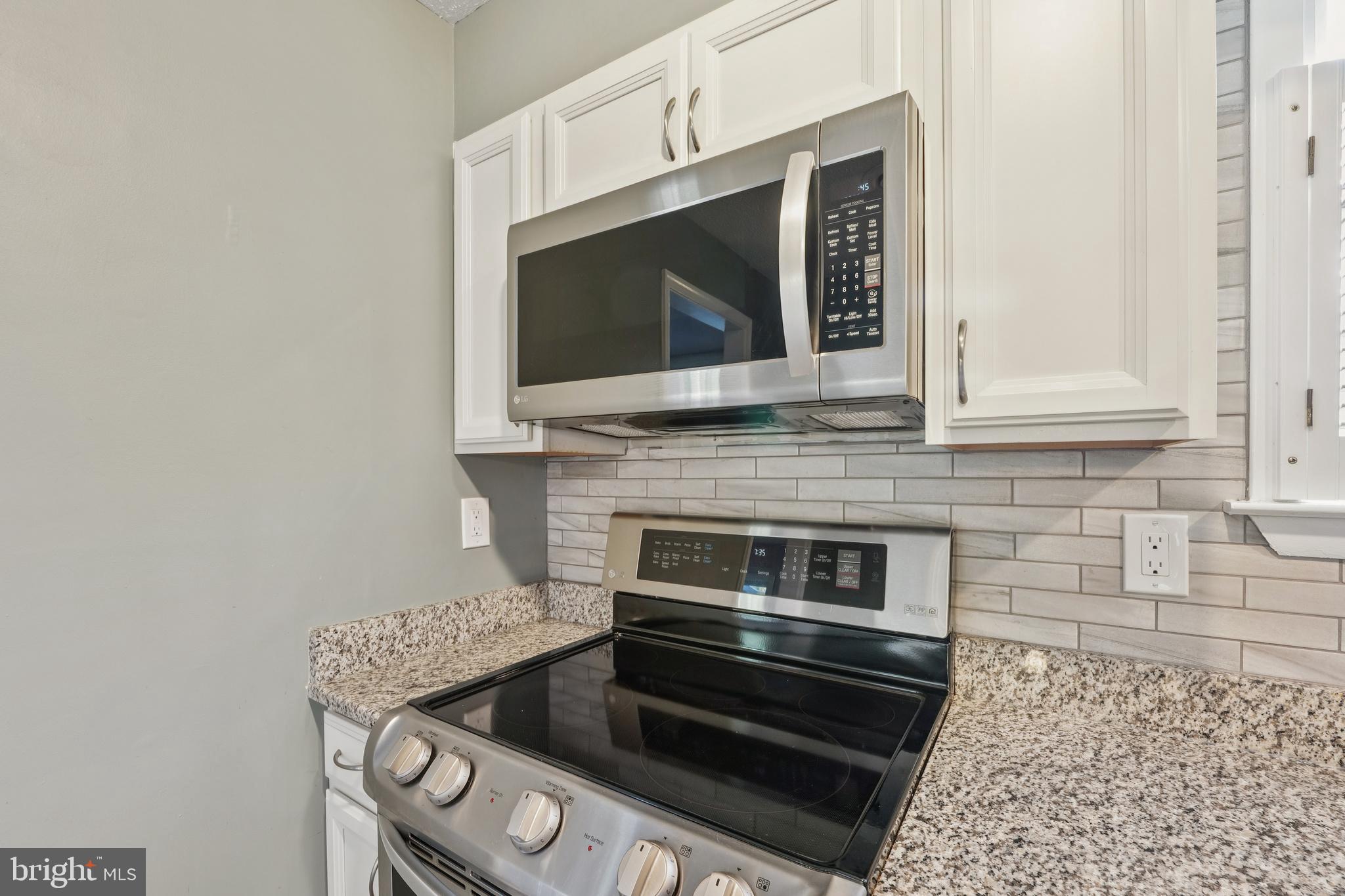 2105 Silver Lane Road Baltimore, MD 21221 - Photo 20 of 55 a kitchen with granite countertop a stove and a microwave