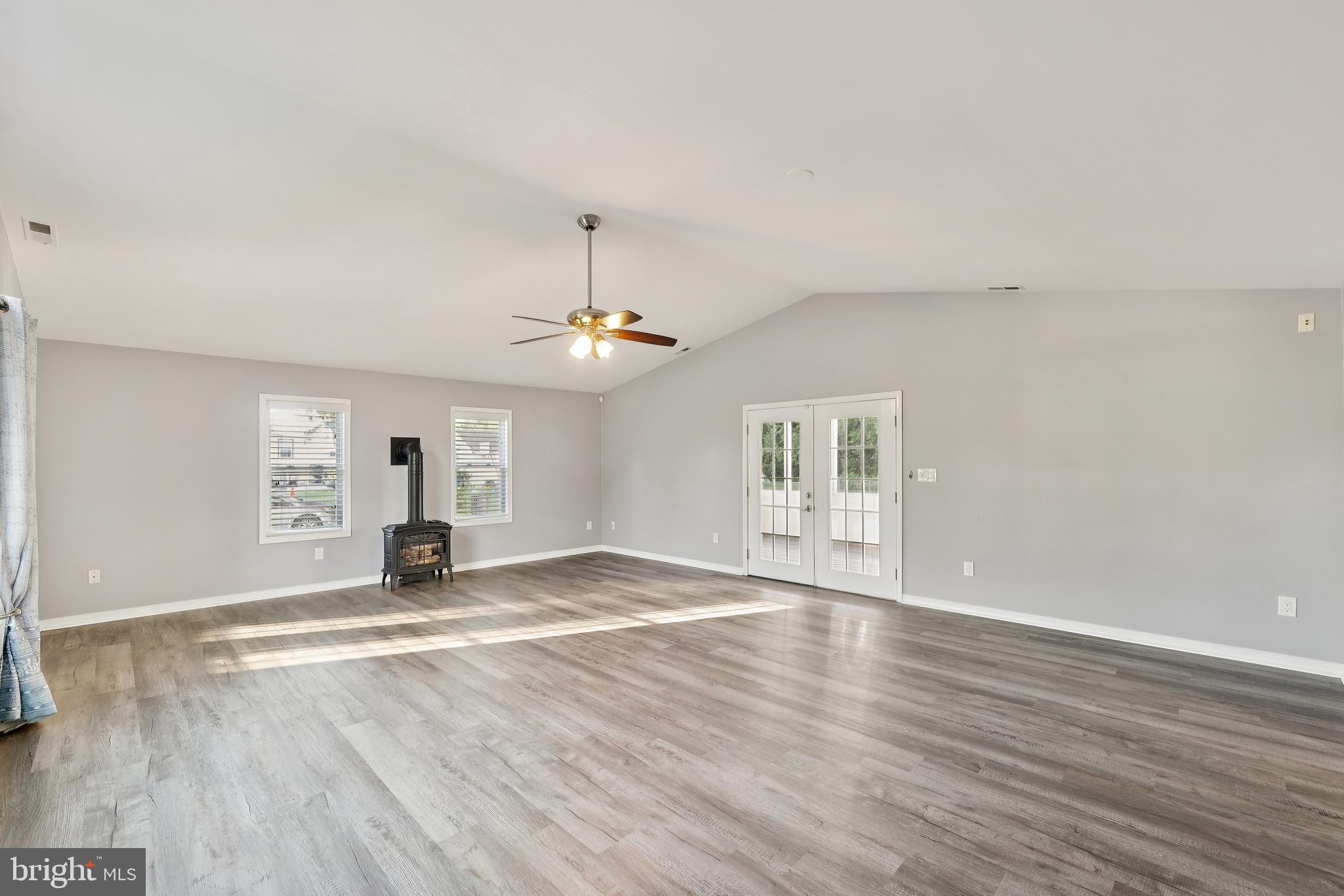 2105 Silver Lane Road Baltimore, MD 21221 - Photo 28 of 55 an empty room with wooden floor a ceiling fan and kitchen view
