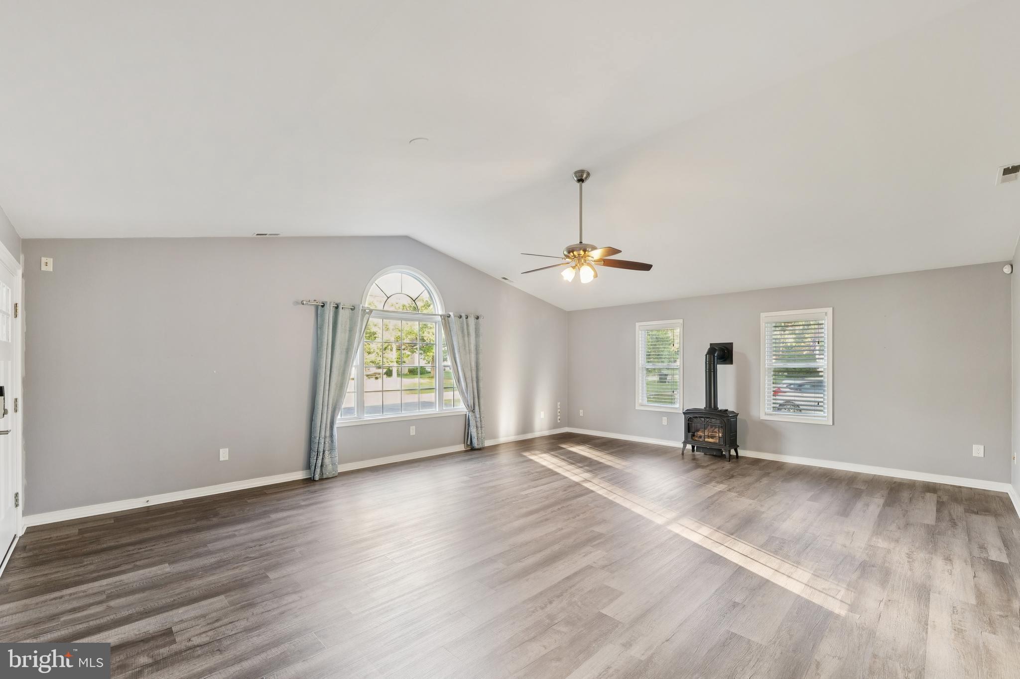 2105 Silver Lane Road Baltimore, MD 21221 - Photo 31 of 55 an empty room with wooden floor chandelier and windows