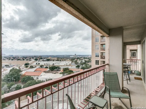 a view of a city from a balcony with furniture