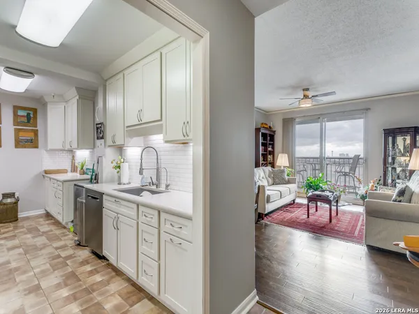 a view of a kitchen with kitchen island a large window cabinets and stainless steel appliances