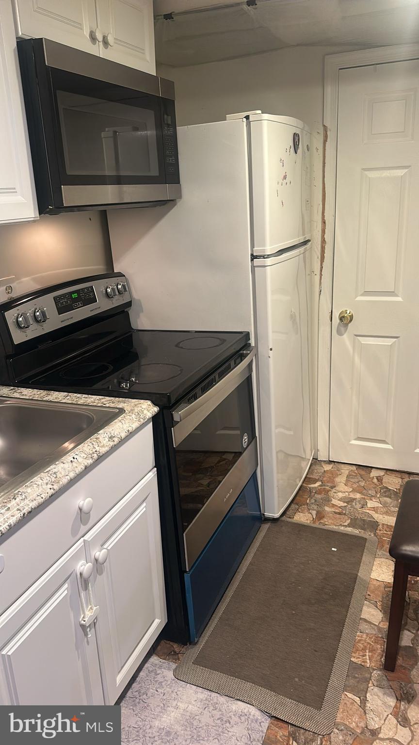 6172 Morning Glory Road Alexandria, VA 22310 - Photo 6 of 6 a view of a kitchen with a stove fridge and wooden floor
