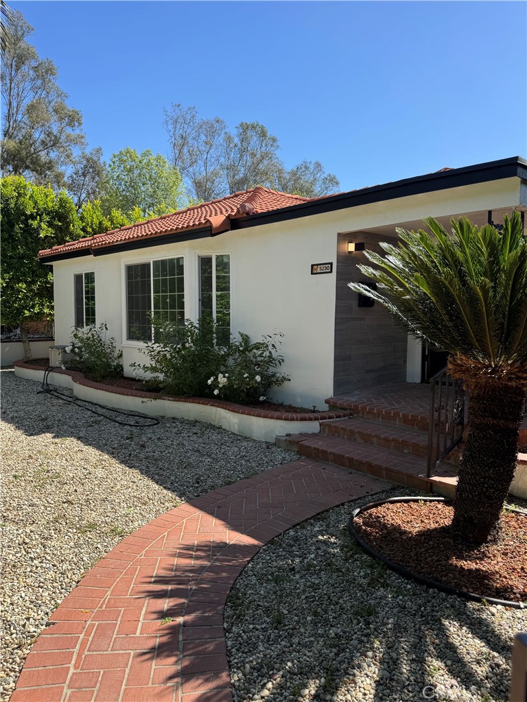 a backyard of a house with potted plants