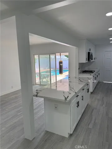 a view of a house with backyard and trees in the background