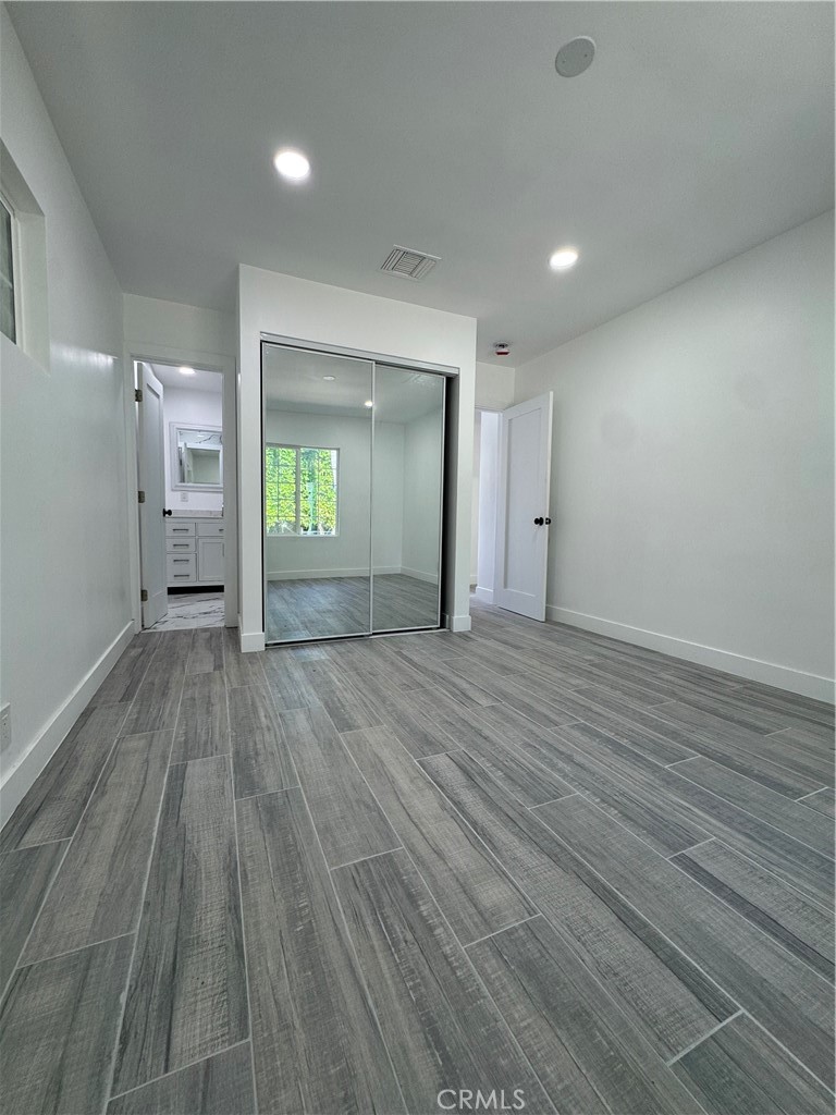 5230 Seville Avenue Encino, CA 91316 - Photo 50 of 61 an empty room with wooden floor and mirror