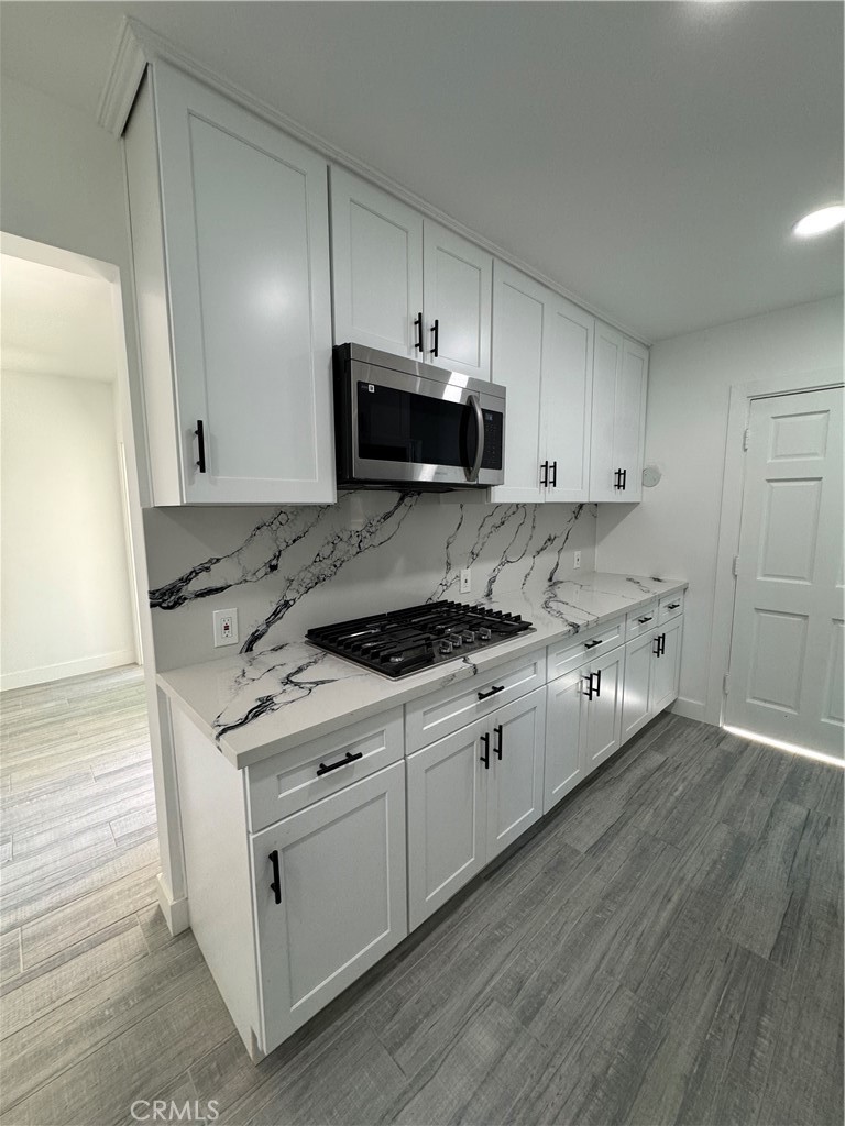 5230 Seville Avenue Encino, CA 91316 - Photo 55 of 61 a kitchen with stainless steel appliances granite countertop a stove a sink and a microwave