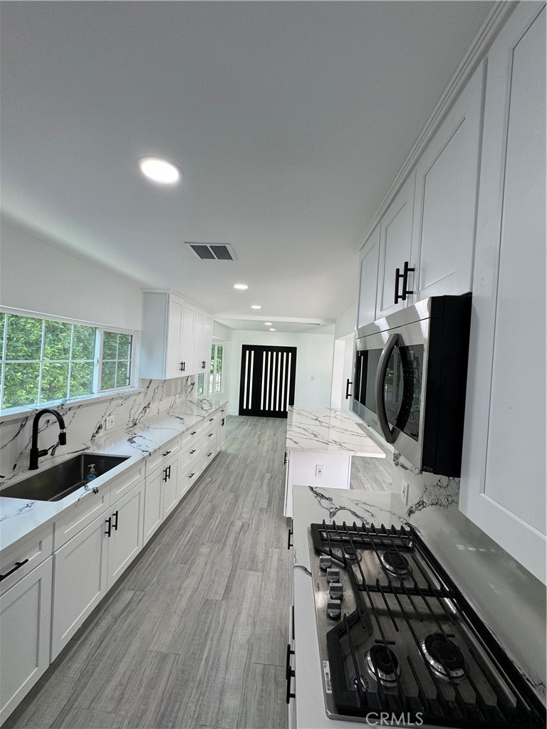 5230 Seville Avenue Encino, CA 91316 - Photo 57 of 61 a large kitchen with a large stove a sink and cabinets