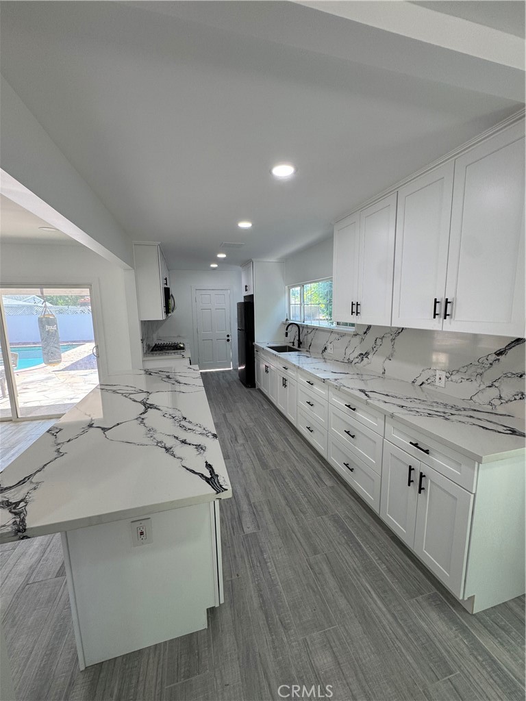 5230 Seville Avenue Encino, CA 91316 - Photo 61 of 61 a large white kitchen with stainless steel appliances granite countertop a stove and a sink