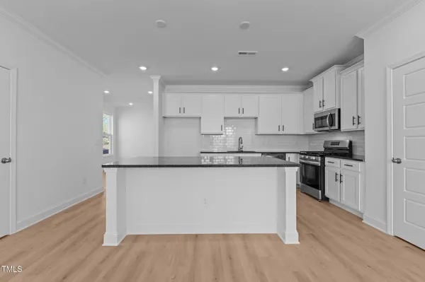 a kitchen with granite countertop white cabinets and stainless steel appliances