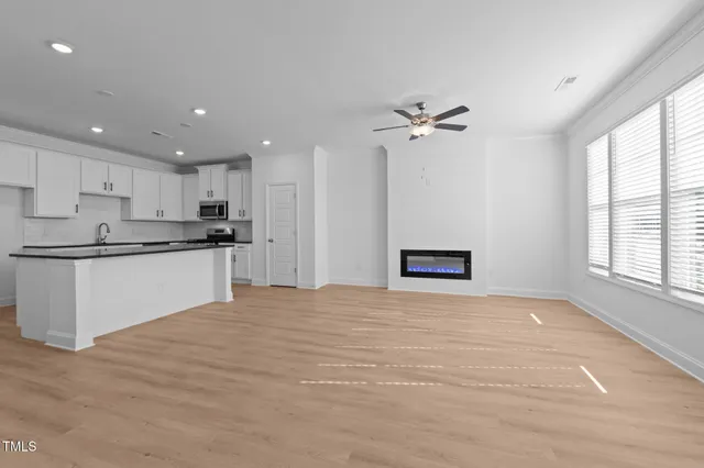a view of an empty room with a window and wooden floor